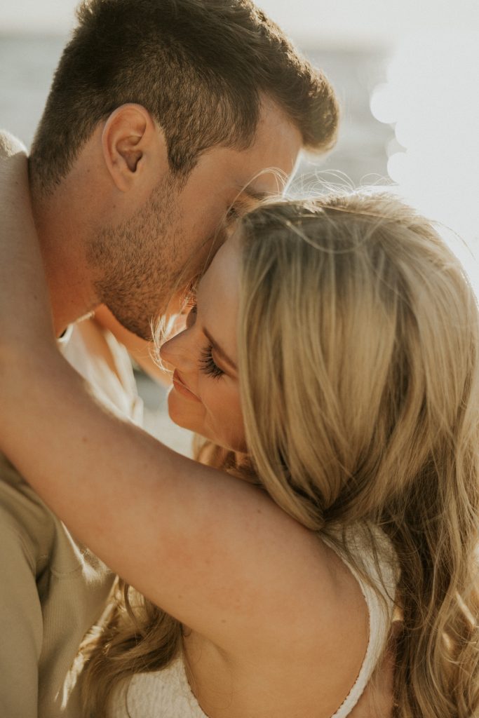 A couple share a tender kiss in soft evening light
