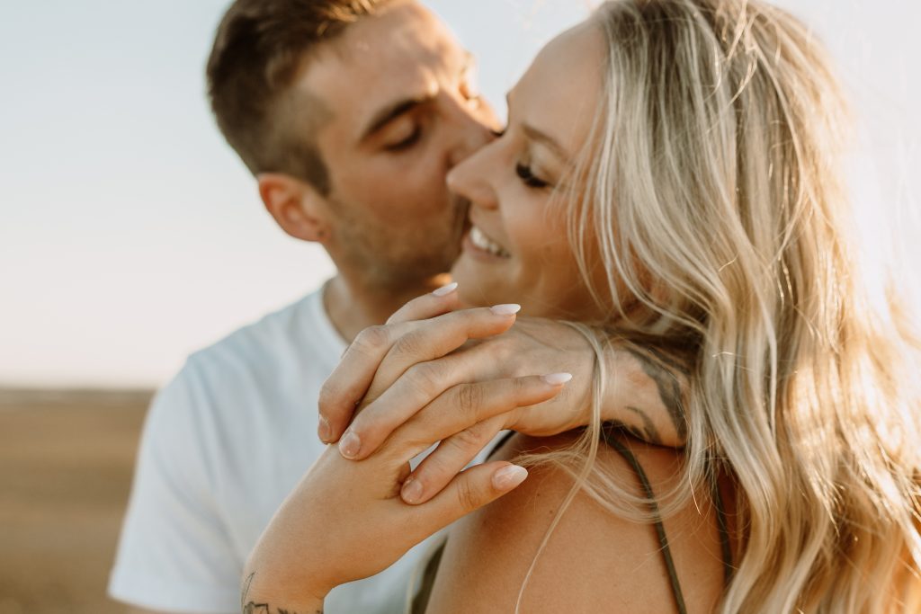 A couple embrace and laugh in warm sunset light