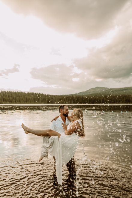 Genuine moments of connection by the lake's golden glow, candid engagement photography