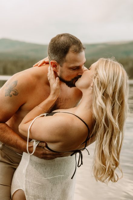 Playful couple takes a spontaneous dip in the lake, candid engagement shoot