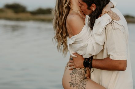 Passionate couple kissing in waist-deep water during sunset session at Vancouver's Mud Bay