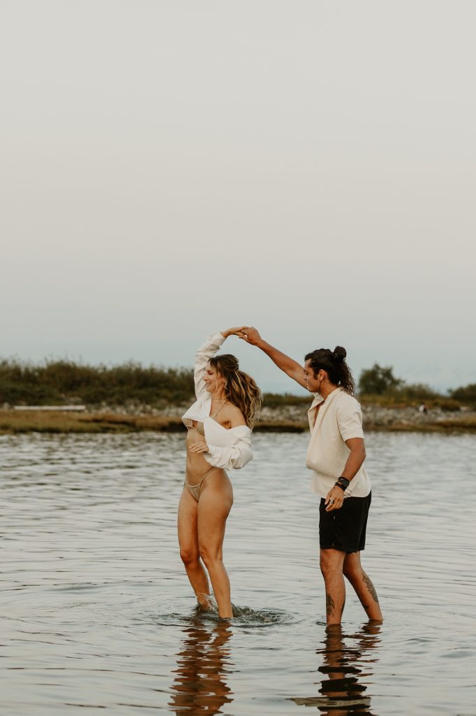 Emotive couple’s portrait in ocean water at dusk near Vancouver’s scenic shoreline