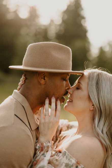 Sweet moment of couple gazing at each other with meadow backdrop
