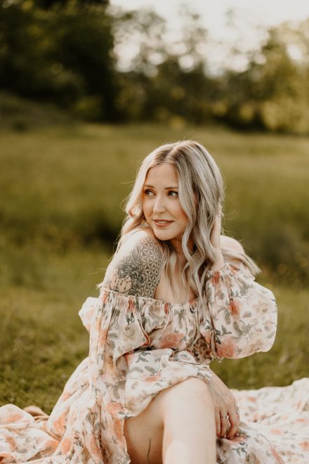 Peaceful moment of woman smiling gently while surrounded by a glowing field of wild grass
