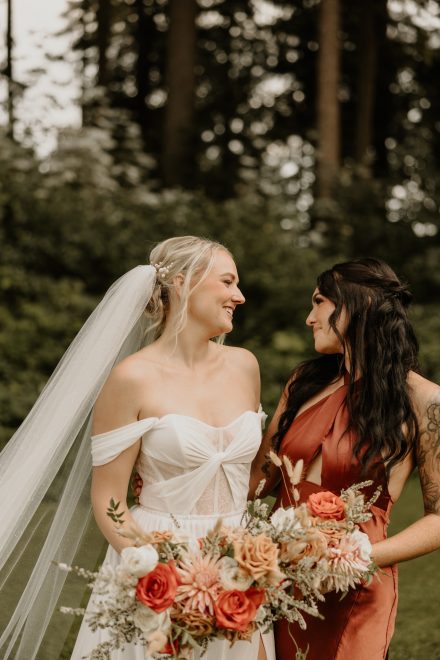 Bridesmaids laughing and holding bouquets in elegant mismatched dresses