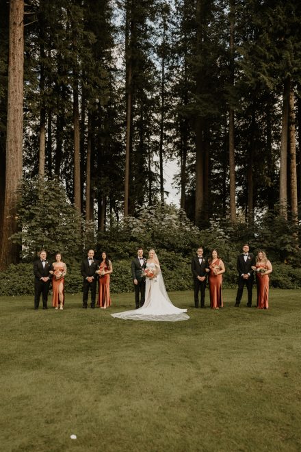 Bridal party lined up with forested Fraser Valley views behind them at Sandpiper Golf Course
