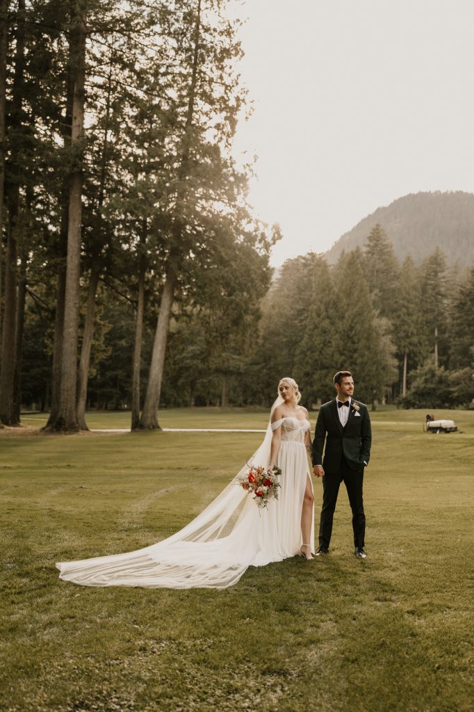 Classic portrait of bride holding bouquet with mountains softly blurred in background