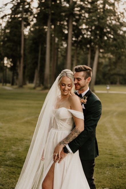 Romantic close-up of couple with heads together framed by tall grasses and golden glow