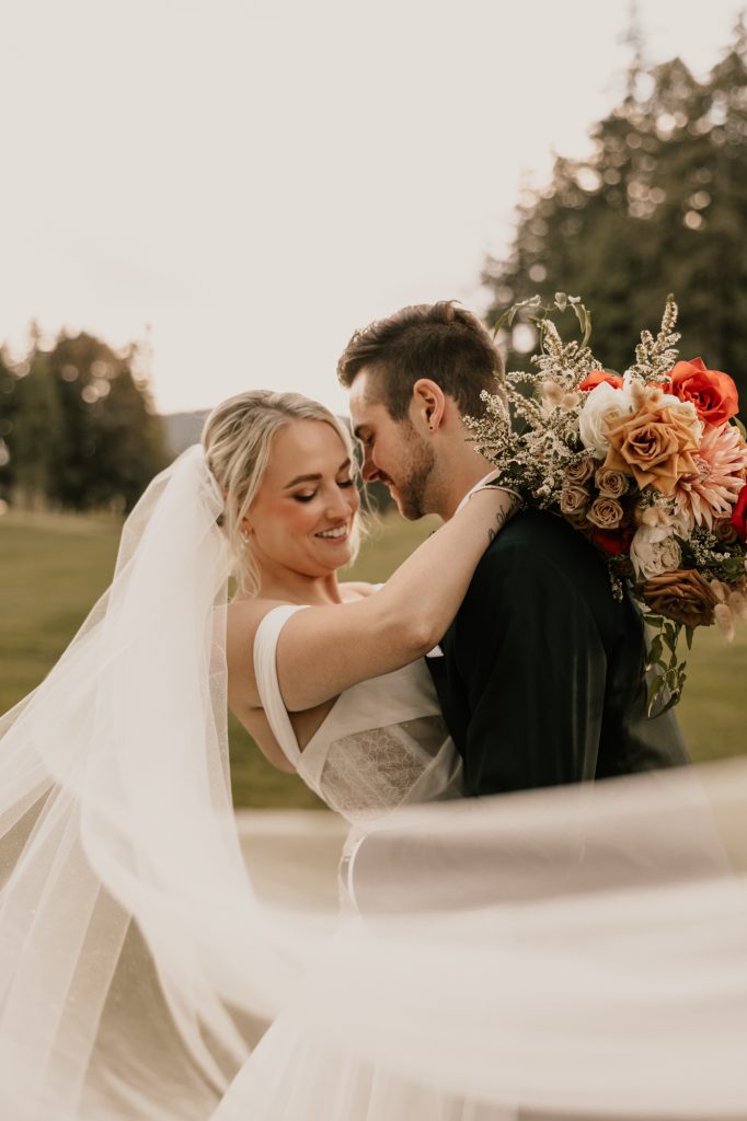 Groom spinning bride in flowing dress during golden hour at Sandpiper Golf Course