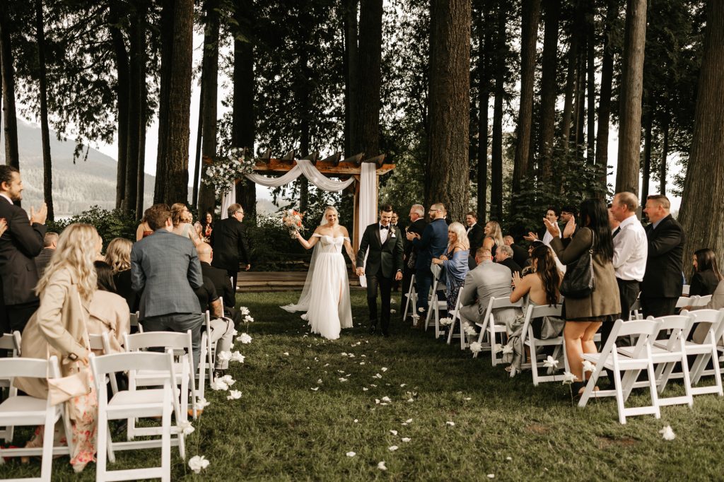Bride and groom walking back down the aisle hand-in-hand as newlyweds