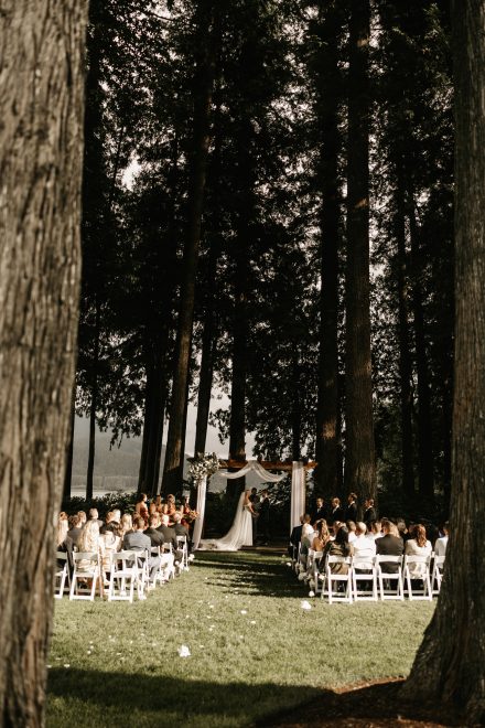 Wide angle of ceremony setup at Rowena’s on the River with mountains and water behind