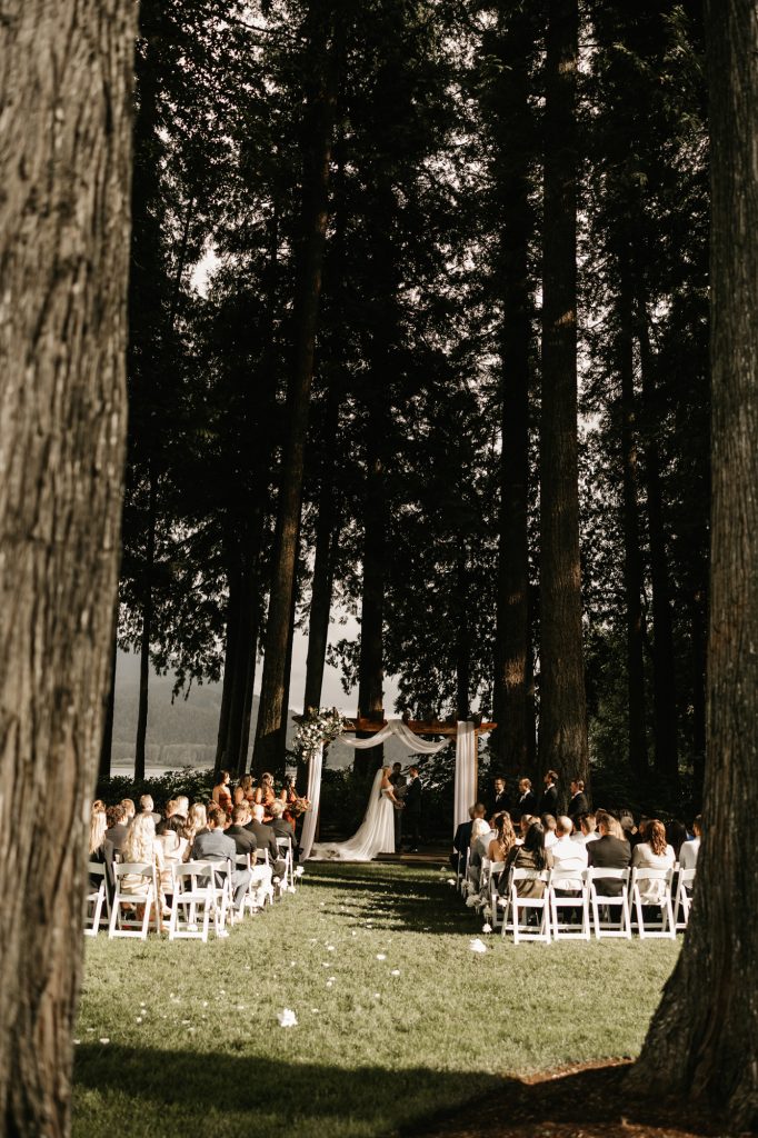 Wide angle of ceremony setup at Rowena’s on the River with mountains and water behind
