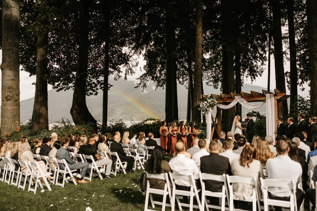 Wide angle of ceremony setup at Rowena’s on the River with mountains and water behind