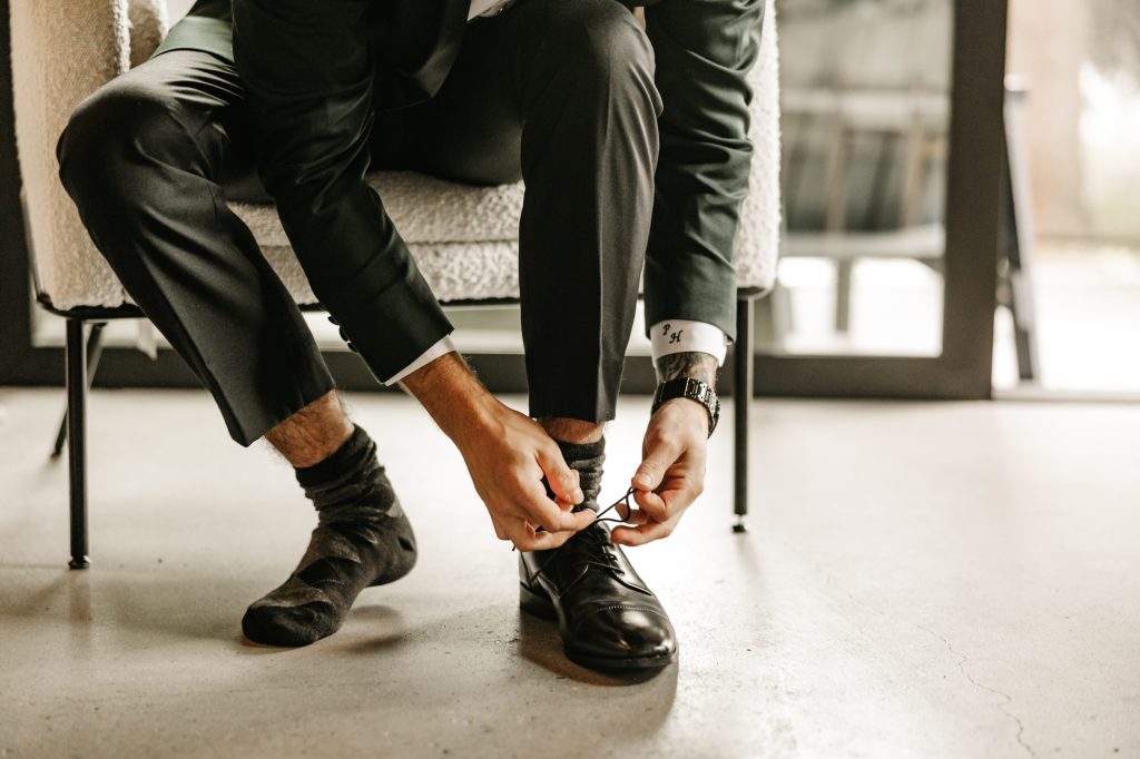 Groom tying his shoes for his wedding day