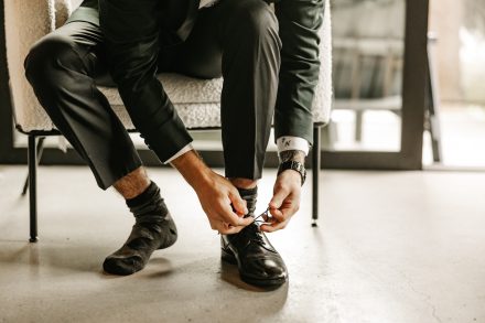 Groom tying his shoes for his wedding day