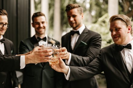 Grooms sharing a drink with his boys before wedding