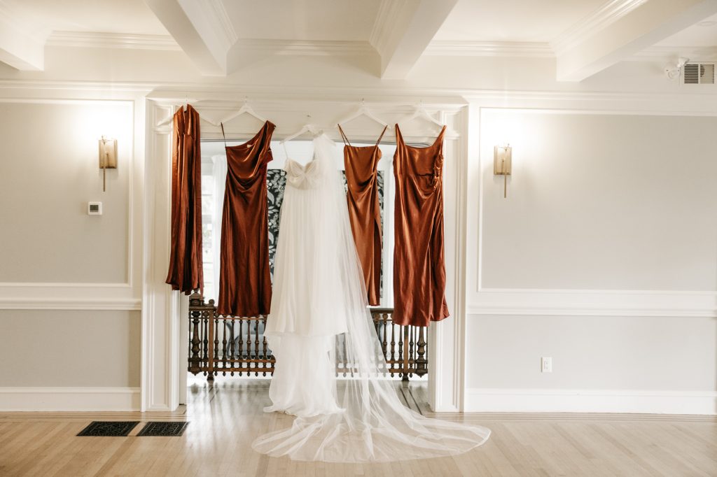 Detail shot of lace wedding gown hanging in window at Sandpiper Golf Course venue