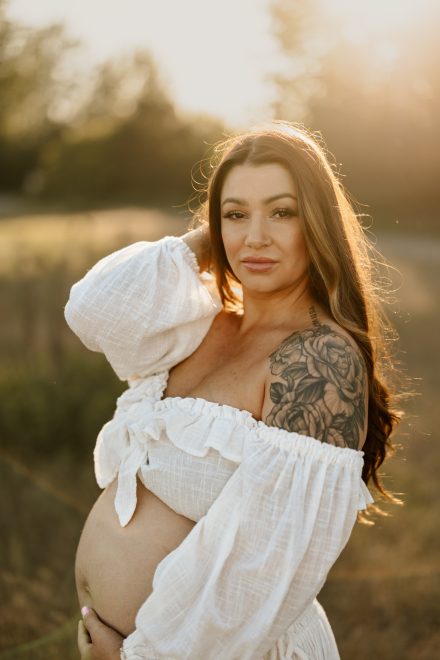 Elegant outdoor maternity photo in a lush field near Vancouver with glowing evening light