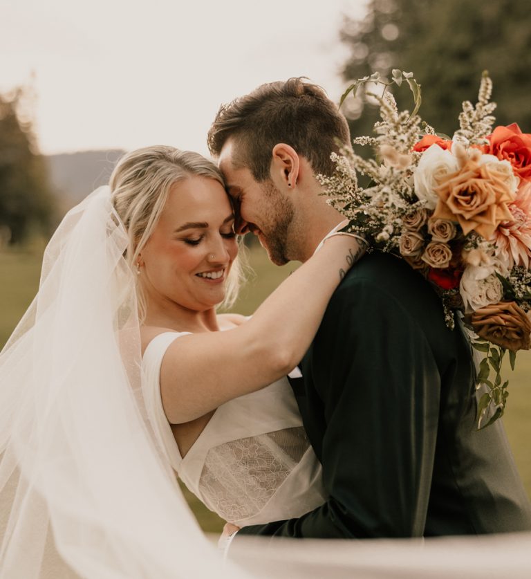 Romantic outdoor wedding ceremony at Rowena's on the River with mountain backdrop in Fraser Valley