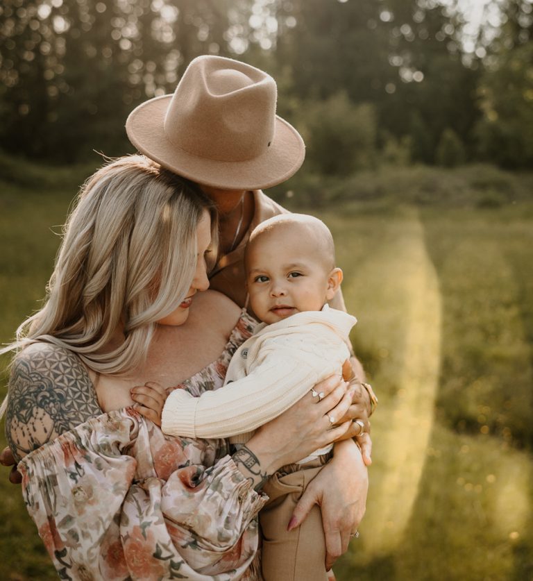 Tender family portrait in golden light, full of soft smiles and connection