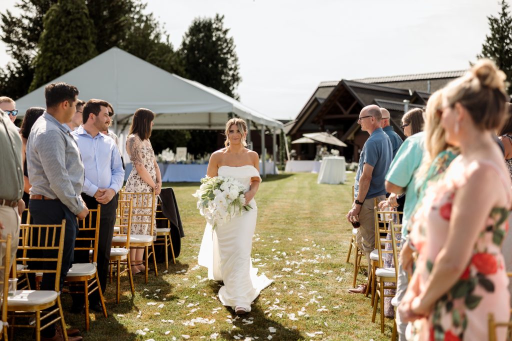 Melissa walking down the aisle at her family backyard wedding in Abbotsford
