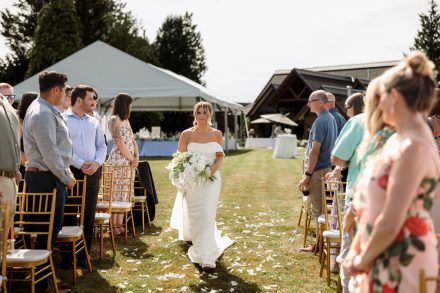 Melissa walking down the aisle at her family backyard wedding in Abbotsford