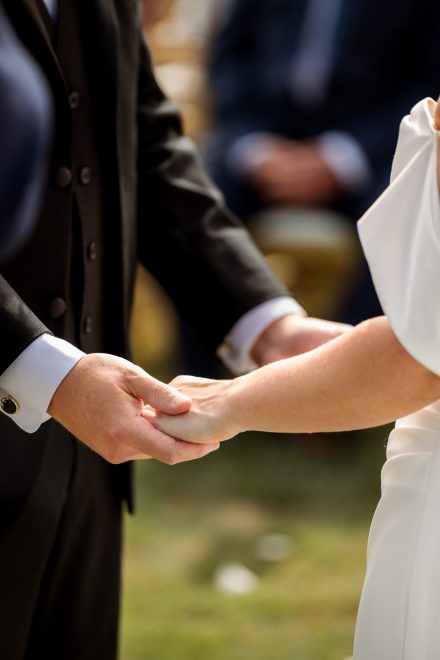 Melissa and Parker holding hands during vows at their Abbotsford summer wedding