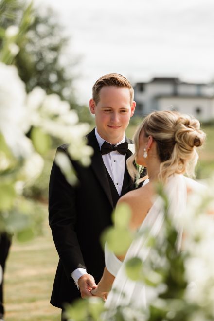 Melissa and Parker holding hands during vows at their Abbotsford summer wedding